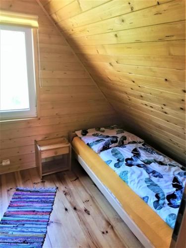 a bedroom with a bed in a log cabin at Kruklanki Domek in Kruklanki