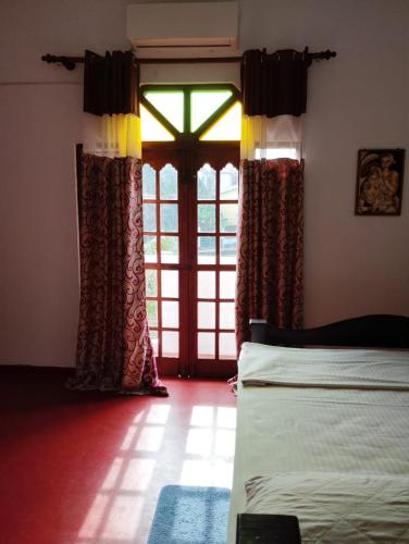 a room with two beds and a large window at Green View in Ambalangoda