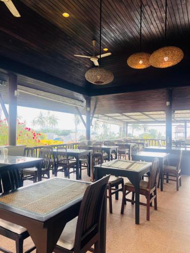 a dining room with tables and chairs and windows at Lamai Buri Resort in Lamai