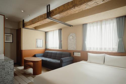 a hotel room with a bed and a couch at Nesthotel alt Kawasaki Station in Kawasaki