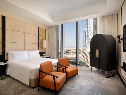 a hotel room with a bed and two chairs at Anantara Downtown Dubai in Dubai
