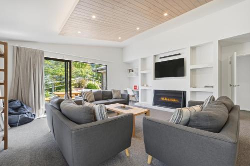 a living room with two couches and a fireplace at Rolki House - Hanmer Springs Holiday Home in Hanmer Springs