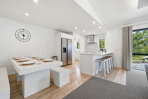 a white kitchen with white counters and a large window at Rolki House - Hanmer Springs Holiday Home in Hanmer Springs