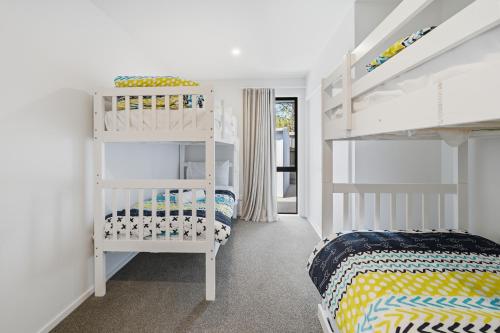 a bedroom with a white bunk bed and a white shelf at Rolki House - Hanmer Springs Holiday Home in Hanmer Springs