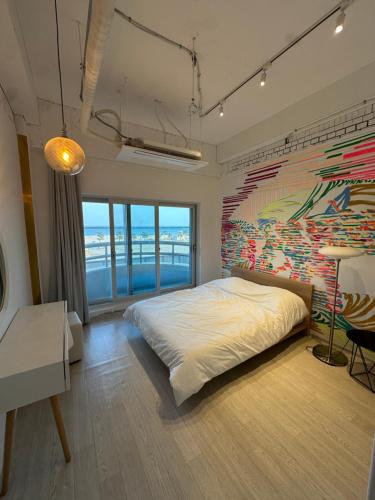 a bedroom with a large bed and a painting on the wall at 명파아트호텔 in Chŏjil-li