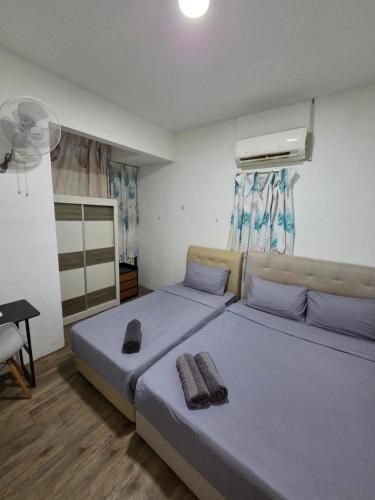 a bedroom with two beds and a fan at Sunny Point Hostel in Gelugor