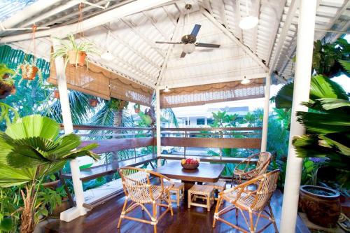 a table and chairs on a balcony with plants at Hotel O Vince Villa in Bukit Mertajam
