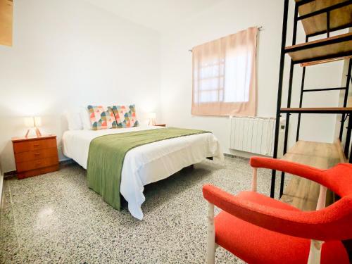 a bedroom with a bed and a red chair at Finca Hoya del Pino in Arafo