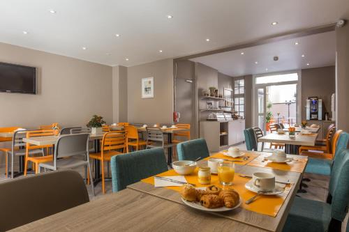 une salle à manger avec une table et des chaises dans l'établissement Paris d'Issy Hôtel Porte de Versailles, à Issy-les-Moulineaux