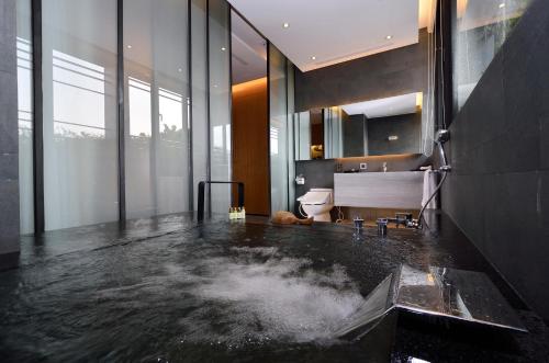 a bathroom with a bath tub with water on the floor at The Sun Hot Spring & Resort in Taichung