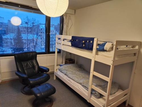 a room with bunk beds and a chair and a window at Spacious Apartment in Kallio in Helsinki