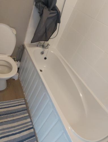 a bathroom with a white tub and a toilet at 3 Bedroom Apartment near the Beach in South Shields