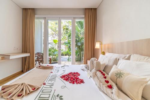 a bedroom with a bed with red flowers on it at The Hita Apartement in Seminyak