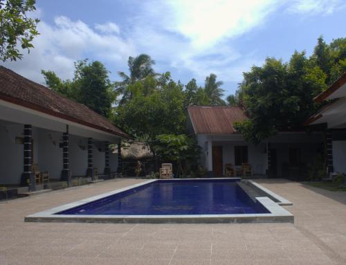 a swimming pool in front of a building at Sawe Homestay in Kuta Lombok