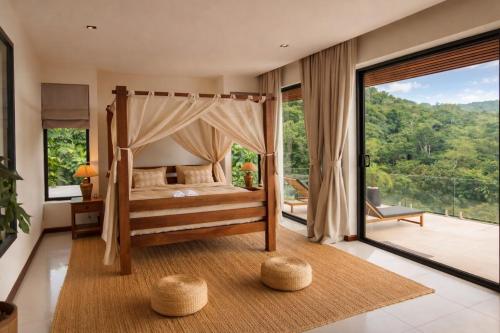 a bedroom with a canopy bed and a balcony at Exclusive Luxury 3-Bedroom Jungle Villa with Private Infinity Pool, Breathtaking Sea View & Peaceful Nature Escape in Mae Nam