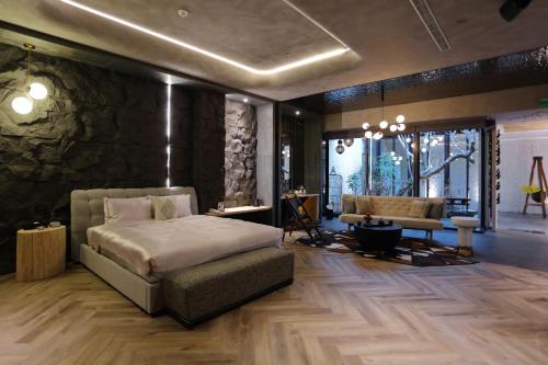 a bedroom with a bed and a stone wall at 沐蘭精品旅館-台北大直館 Mulan Boutique Hotel in Taipei