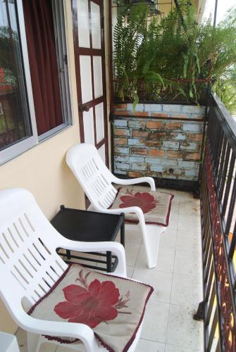 two white chairs sitting on a porch at NB House in Karon Beach