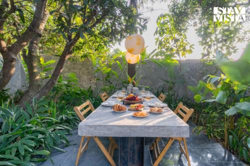 a table with food on it in a garden at StayVista at Matchbox with Pet-Friendly, BBQ & Lawn in Hosūr