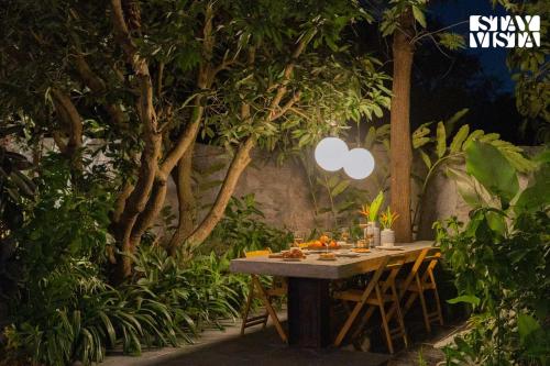 a table in a garden with an apple sign on it at StayVista at Matchbox with Pet-Friendly, BBQ & Lawn in Hosūr