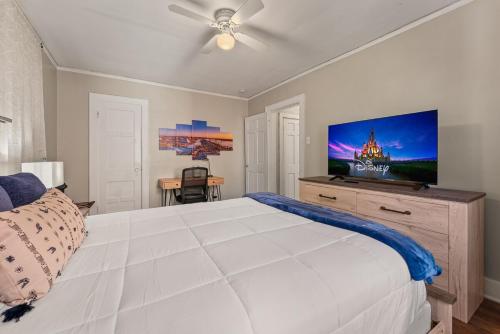 a bedroom with a large white bed and a flat screen tv at Charming 1 Bedroom Duplex in Memphis 2 Miles from Midtown and Crosstown Free WiFi Pet Friendly in Memphis