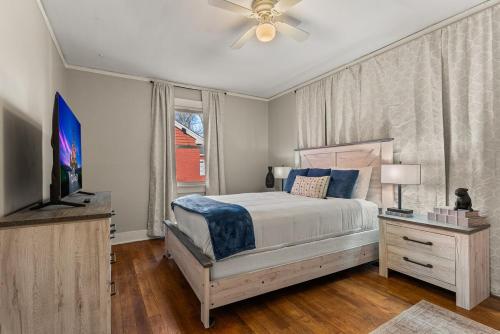 a bedroom with a bed with a ceiling fan and a television at Charming 1 Bedroom Duplex in Memphis 2 Miles from Midtown and Crosstown Free WiFi Pet Friendly in Memphis