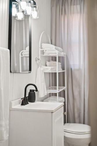 a bathroom with a sink and a toilet and a mirror at Charming 1 Bedroom Duplex in Memphis 2 Miles from Midtown and Crosstown Free WiFi Pet Friendly in Memphis