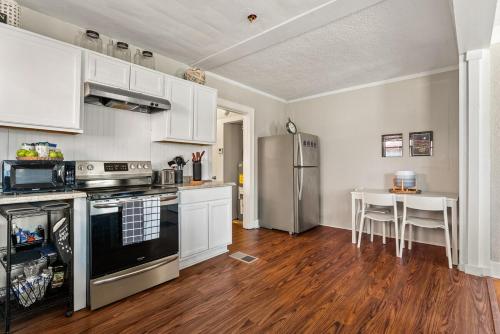a kitchen with white cabinets and a stainless steel refrigerator at Charming 1 Bedroom Duplex in Memphis 2 Miles from Midtown and Crosstown Free WiFi Pet Friendly in Memphis