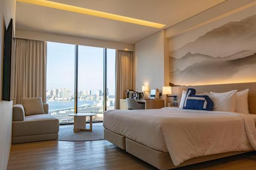 a hotel room with a bed and a large window at Homm Marina Sokcho in Sokcho