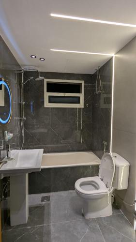 a bathroom with a toilet and a sink at Coral Bay King Studio in Khor Fakkan