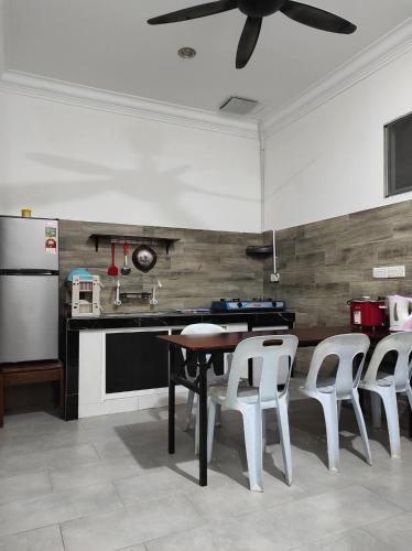 a kitchen with a table and chairs and a refrigerator at House 21 in Lahad Datu