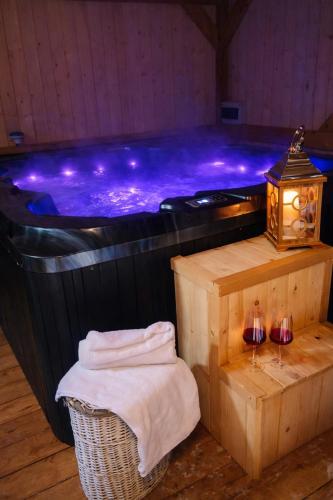 a hot tub with two glasses of wine and a table with towels at Domek u Anitki i Nikosia in Jeleśnia