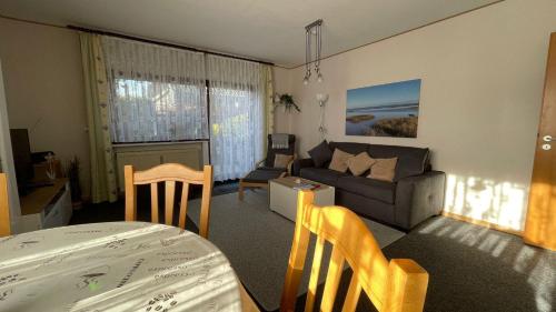 a living room with a couch and a table at Ferienwohnung Auszeit Erika 1 in Burhave