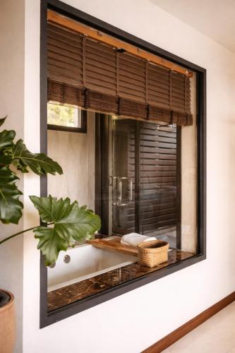 a window with a view of a kitchen at Exclusive Luxury 3-Bedroom Jungle Villa with Private Infinity Pool, Breathtaking Sea View & Peaceful Nature Escape in Mae Nam