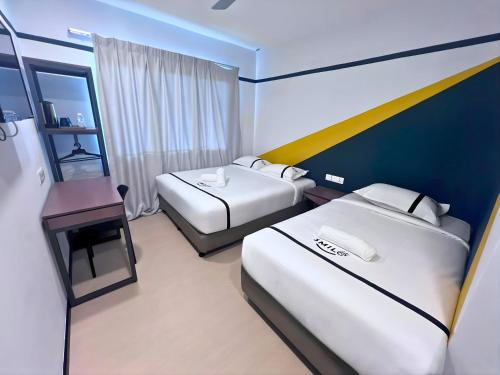 a hotel room with two beds and a desk at Smile Hotel Damansara Tropical in Petaling Jaya
