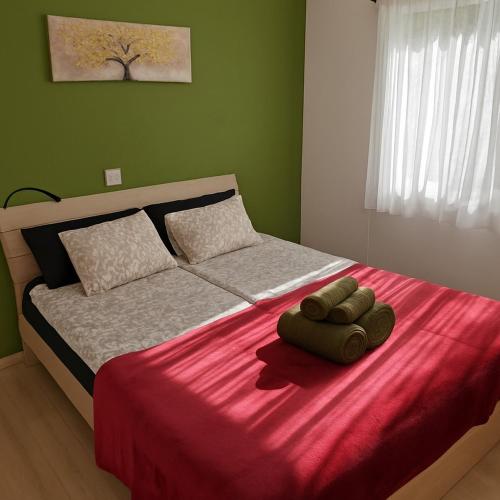 a bedroom with a bed with a red blanket at Apartment with sea view! in Khlorakas