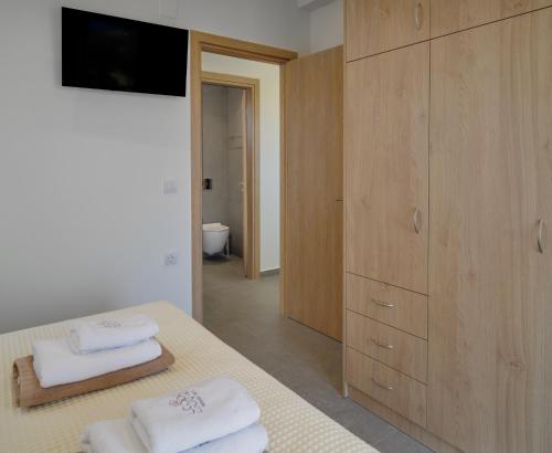 a bedroom with a bed with towels and a cabinet at Utopia Luxury Villas in Gouves