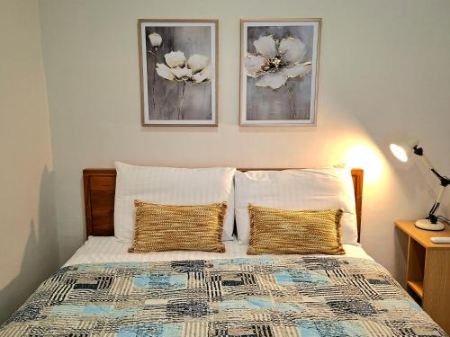 a bedroom with a bed with two pictures on the wall at Tio Homestay in Praya