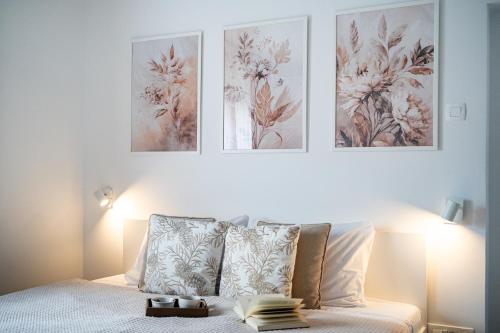 a bedroom with a bed with three pictures on the wall at Apartma pod macesnom in Jesenice