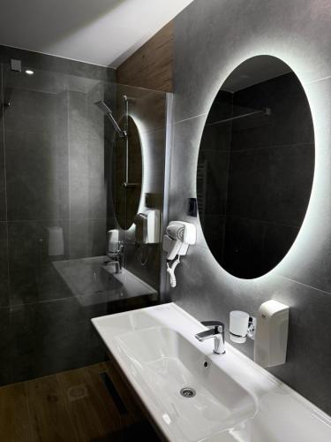 a bathroom with a sink and a mirror at Motel M Vlasenica in Vlasenica