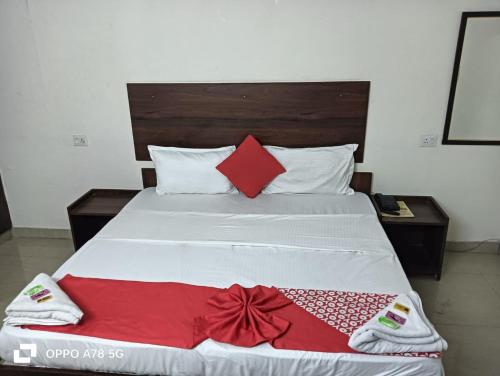 a bed with red and white blankets and pillows at Hotel Mittal Tower in Jhājra