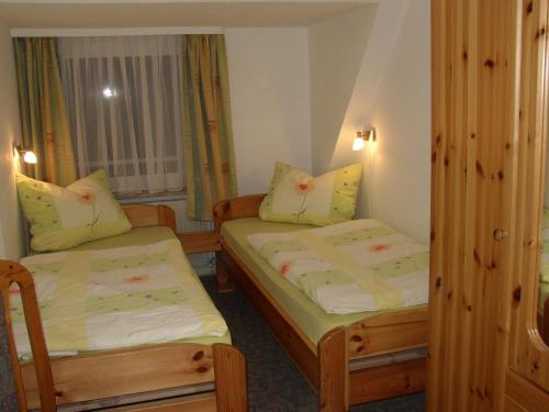 a small room with two beds and a window at Gästehaus Nis Puk und Ferienwohnungen in Büsum