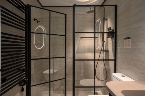 a shower with a glass door in a bathroom at Smartrental Collection Gran Vía Centric in Madrid