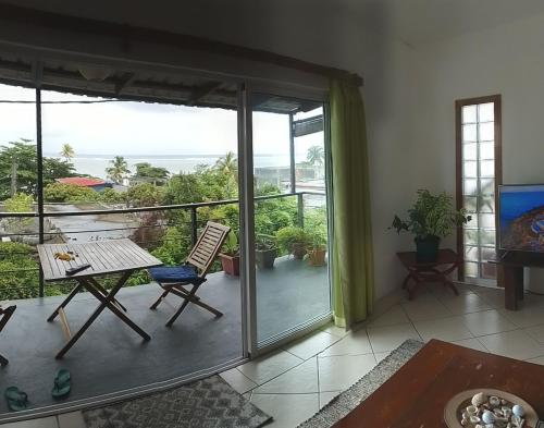 a room with a balcony with a table and chairs at Surf house holidays in Ruisseau Créole