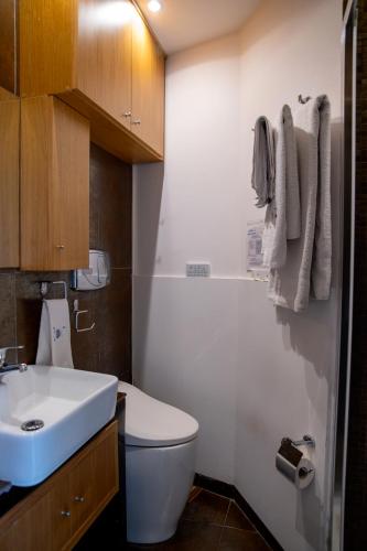 a bathroom with a white toilet and a sink at Alba Chiara in Acitrezza