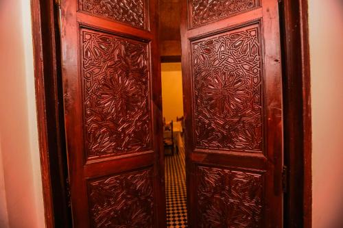 a pair of wooden doors in a room at Palais Nazha Fes - Luxury Lodging in Fès