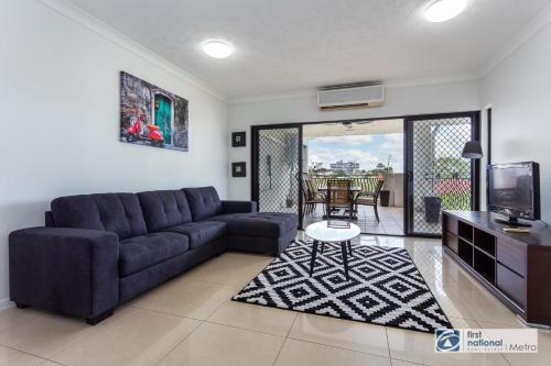 a living room with a couch and a tv at Southbank Parkside Two-Bed Villa in Brisbane