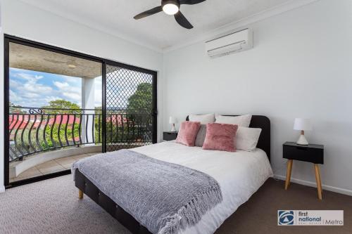 a white bedroom with a bed and a balcony at Southbank Parkside Two-Bed Villa in Brisbane