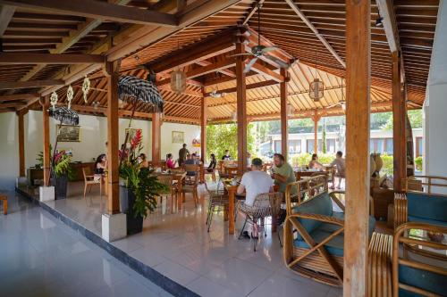 a group of people sitting at tables in a restaurant at Pertiwi Bisma 1 in Ubud