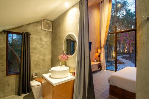 a bathroom with a toilet and a sink and a mirror at Issara Bar&House in Ko Larn