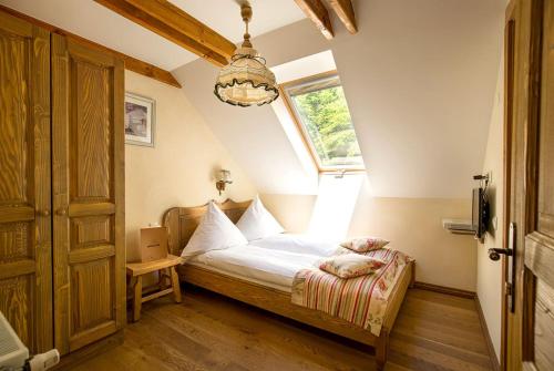 a bedroom with a bed with a window and a chandelier at Cabana Plaiul Foii in Zărneşti